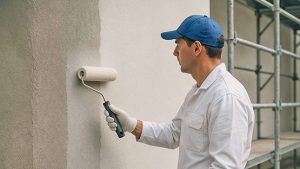 Maler streicht Außenfassade.