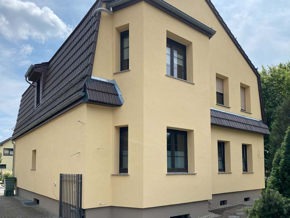 Mehrfamilienhaus gelb nach Fassadensanierung